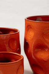 Set of 3 terracotta plant pots in orange color.
