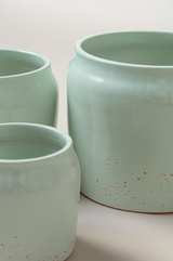close up of set of three Terracotta glazed plant pots of different sizes in mint green color