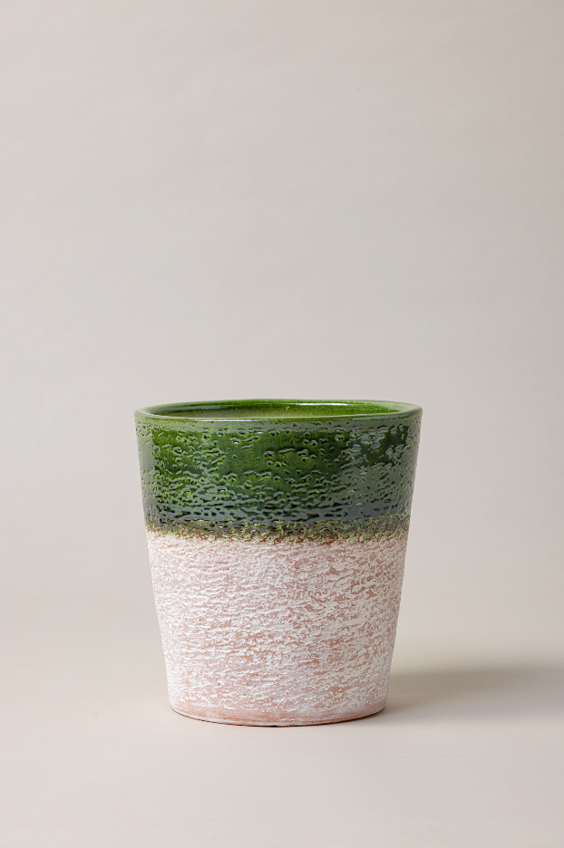 Aged terracotta glazed plant pot in green color.