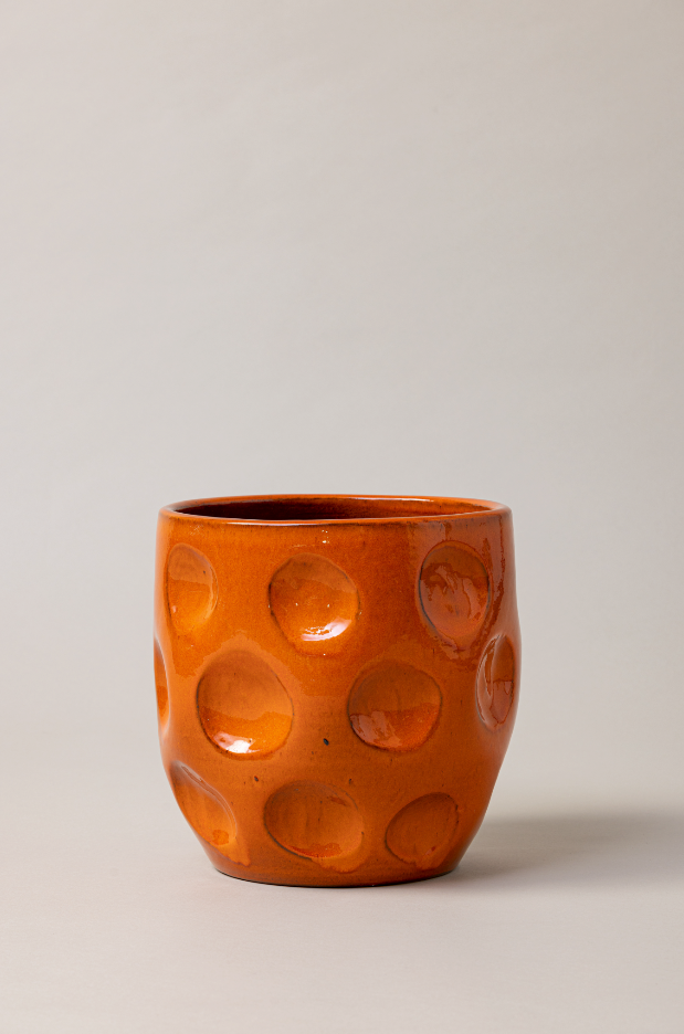 Terracotta glazed plant pot in orange color.