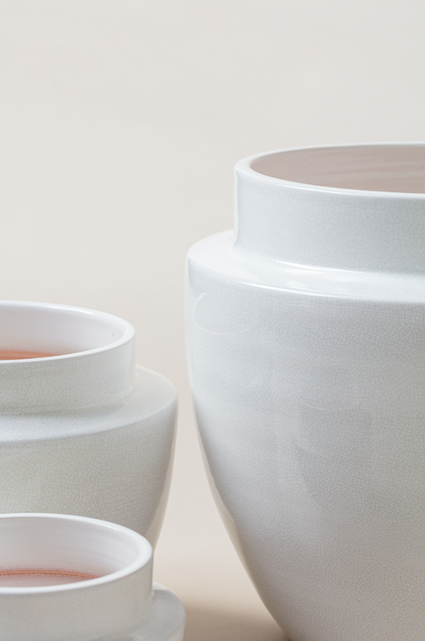 close up of set of three Terracotta glazed plant pots of different sizes in white craclé color