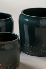 close up of set of three Terracotta glazed plant pots of different sizes in juniper green color