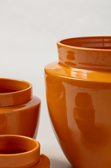 close up of set of three Terracotta glazed plant pots in yellow color
